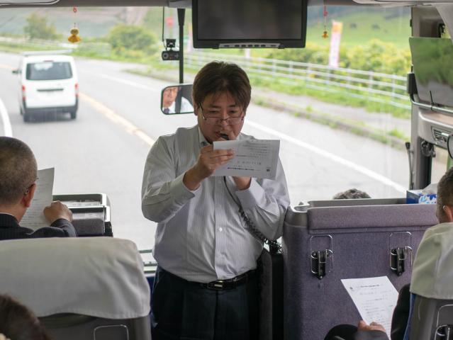 車中例会で報告する幹事L村田修