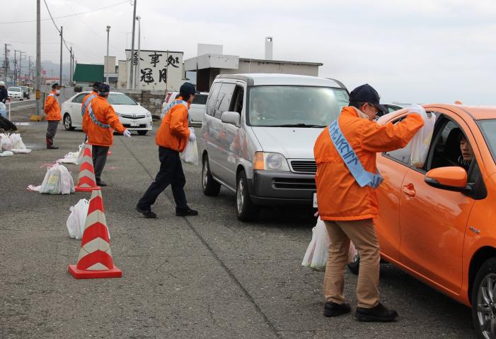 ドライバーにドリンクなどが入った袋を渡して、安全運転の呼びかけ。