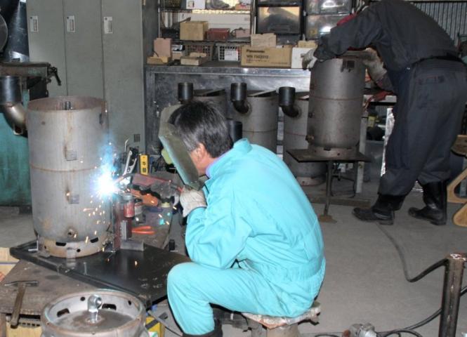 障がい者就労支援事業所で加工された部品を使用し、ストーブを製作する熟練技術者