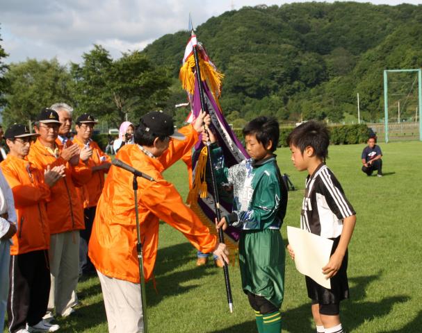 L.蚊野好之会長から優勝旗の贈呈