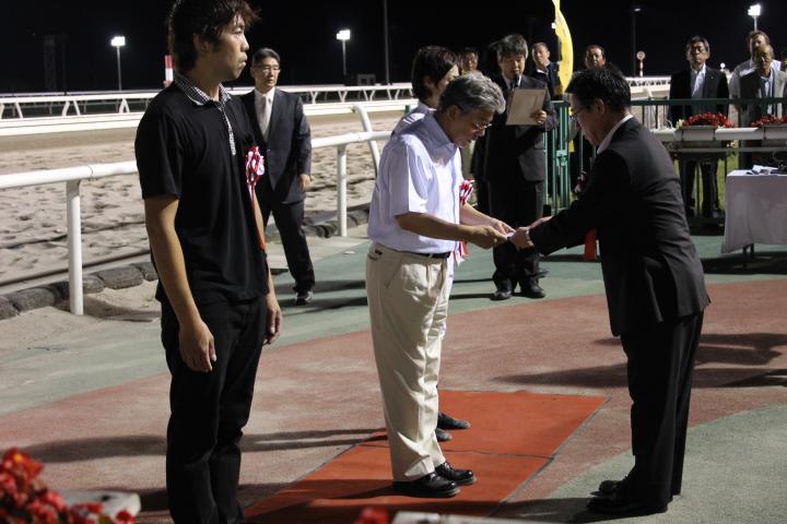 田畑会長が、プレゼンターとして記念品を贈る。