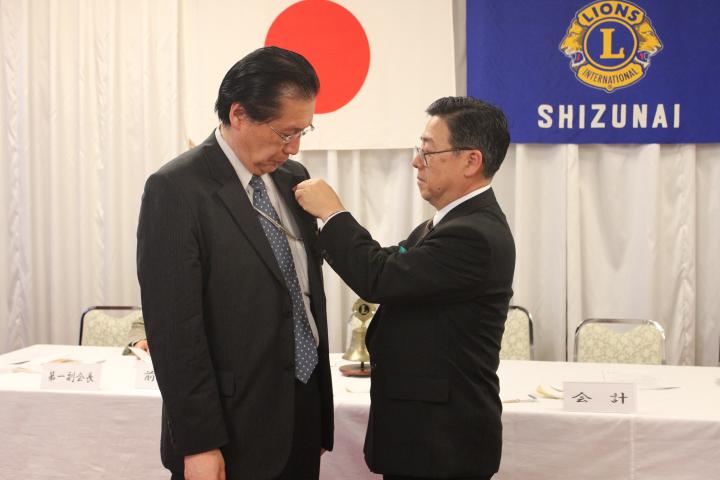 お疲れ様でした。Ｌ田畑会長、次期会長Ｌ梅庭和敏へと襟章の引継ぎが行なわれました。ずっしりと重たいバッジです。