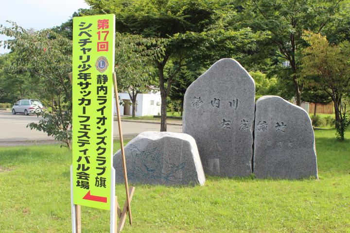 晴天の下、看板がサッカー会場へ誘導する。