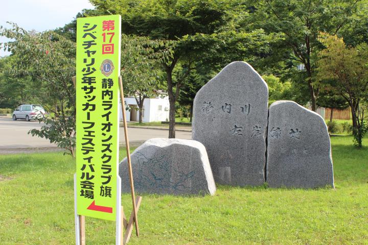 晴天の下、看板がサッカー会場へ誘導する。