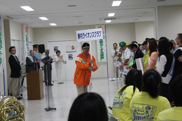 プラカードを高く掲げる静内LC幹事、L菅沼学