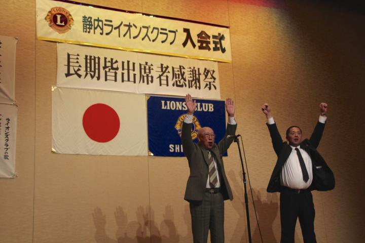 締めのローアは、会員委員長L沼田正男が新入会員新会員L岡本晃をステージに呼んだ。